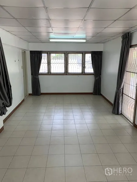 办公空间 出租在Chatuchak, Bangkok - 狭长会议室，白色地砖，多扇窗与深色窗帘。