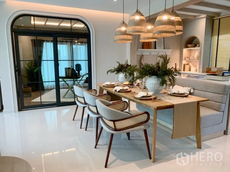 Detached House for sale - Dining room featuring a six-seat wooden table, rattan pendant lights, banquette seating and glass doors to a flex room.