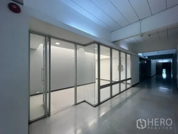 Office Space for rent in Mueang Samut Prakan, Samut Prakan - Glass-fronted office suite along a corridor with recessed lighting.