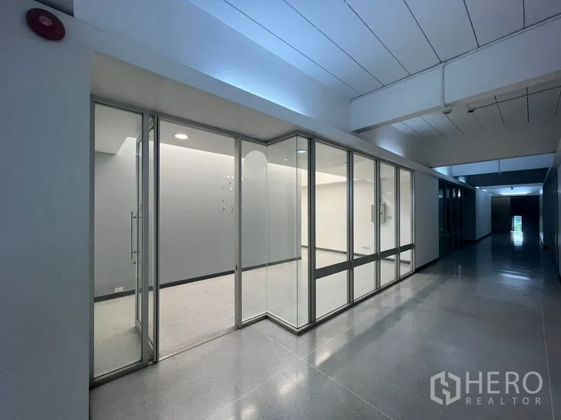 Office Space for rent in Mueang Samut Prakan, Samut Prakan - Glass-fronted office suite along a corridor with recessed lighting.