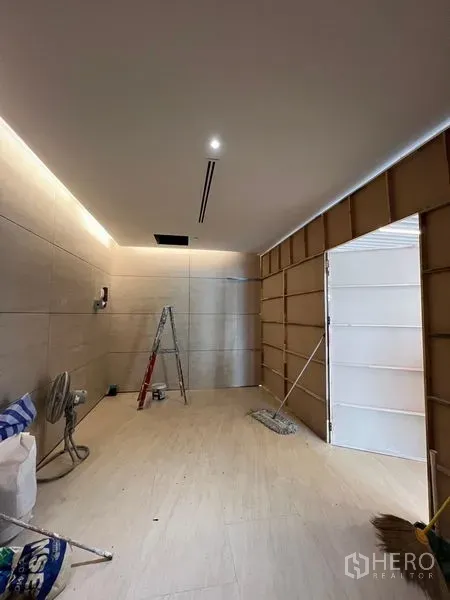 零售空间 出租在Pathum Wan, Bangkok - 正在翻修的紧凑商铺，浅色地砖、嵌入式照明与梯子可见。