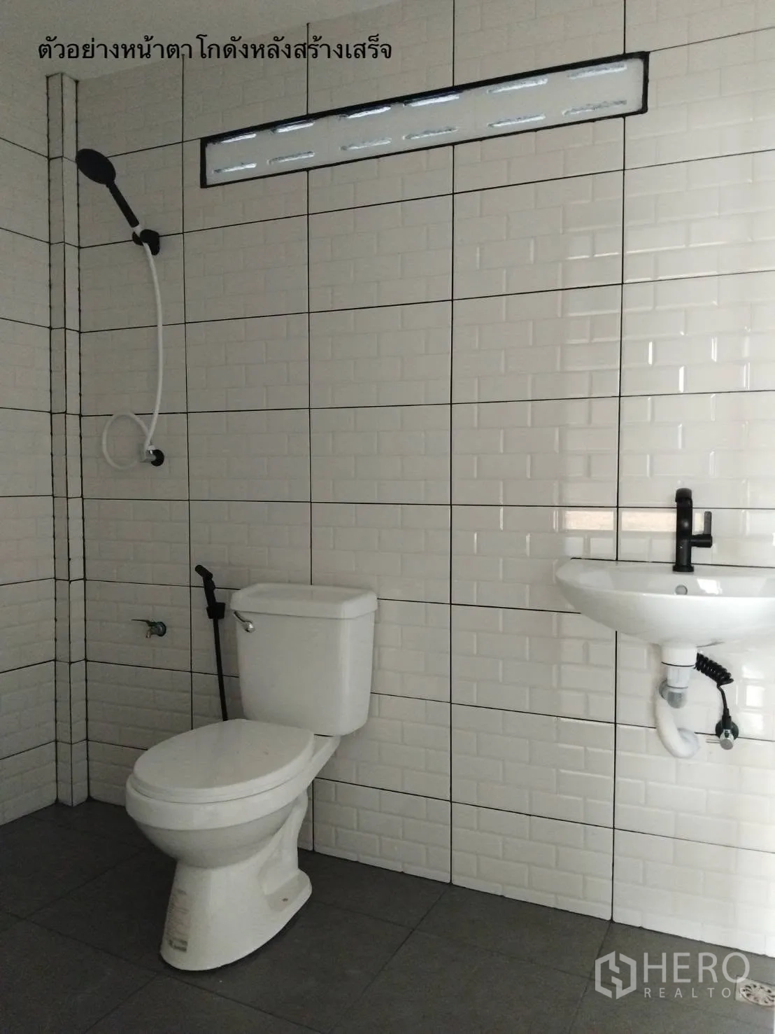 Warehouse for rent in Bang Kapi, Bangkok - Tiled restroom with toilet, sink, hand shower, and ventilation slot inside the warehouse.