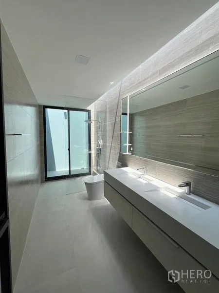 Detached House for rent in Saphan Sung, Bangkok - Contemporary bathroom with long double vanity, walk-in shower and daylight.