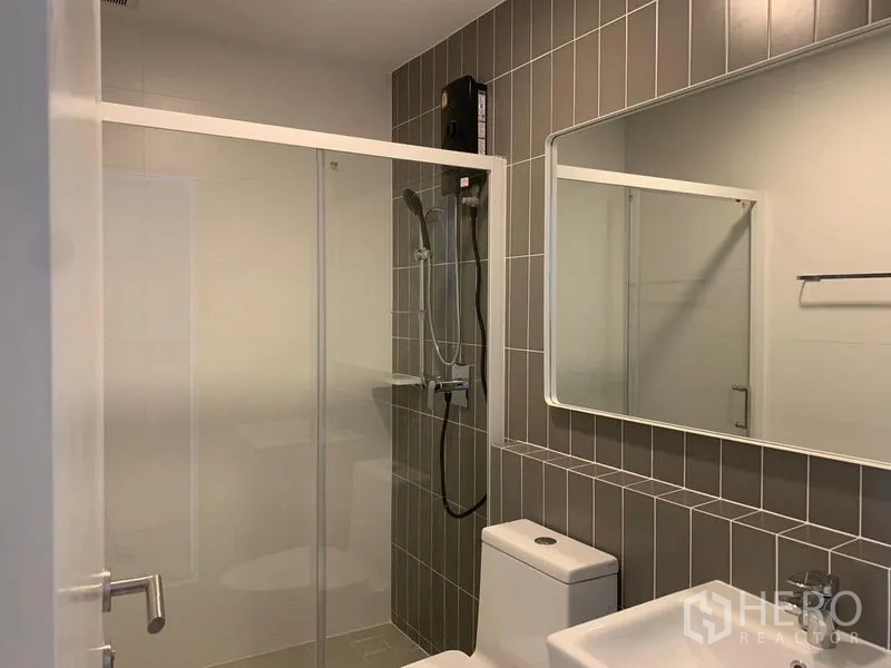 联排别墅 出租 - 灰色调浴室，玻璃隔断淋浴、洗手台与坐便器。