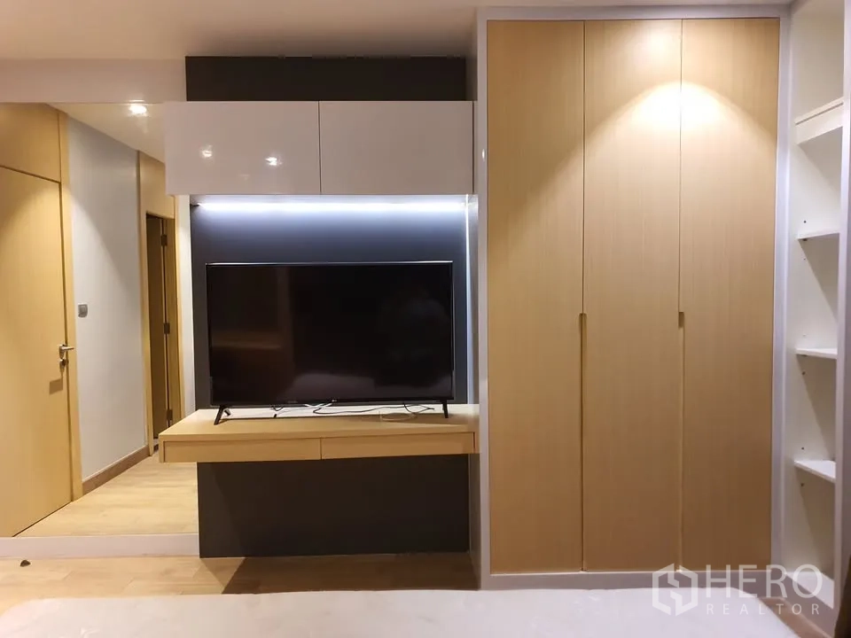 คอนโด for rent in Watthana, Bangkok - ผนังทีวีบิลต์อินพร้อมชั้นลอย ตู้เสื้อผ้าไม้ และชั้นวางในห้องนอน