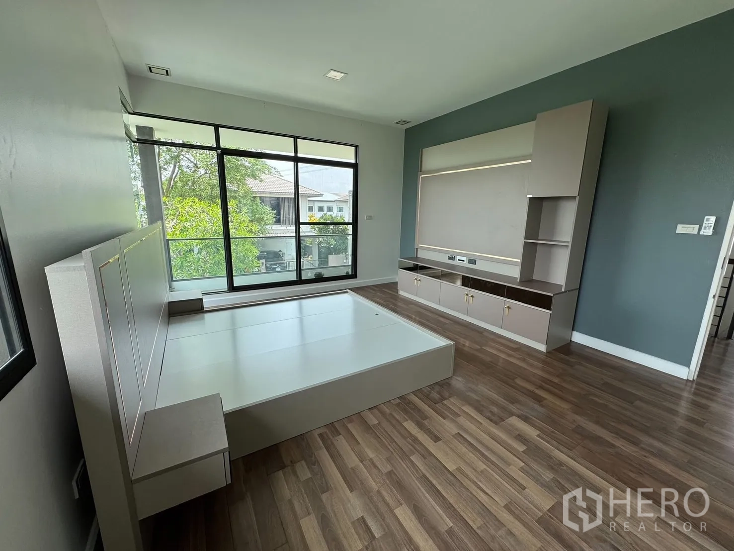 Detached House for rent in Prawet, Bangkok - Bedroom with large sliding glass doors to the balcony and a built-in TV console.