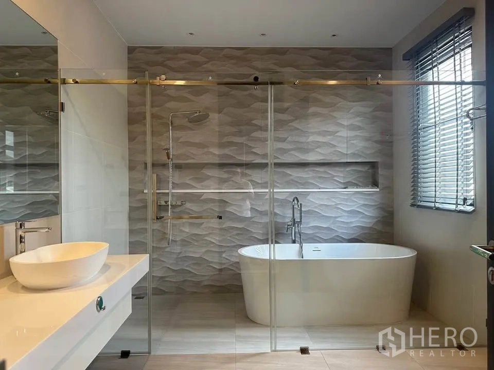 Detached House for sale in Watthana, Bangkok - Contemporary bathroom with freestanding bathtub, glass shower, and vanity.