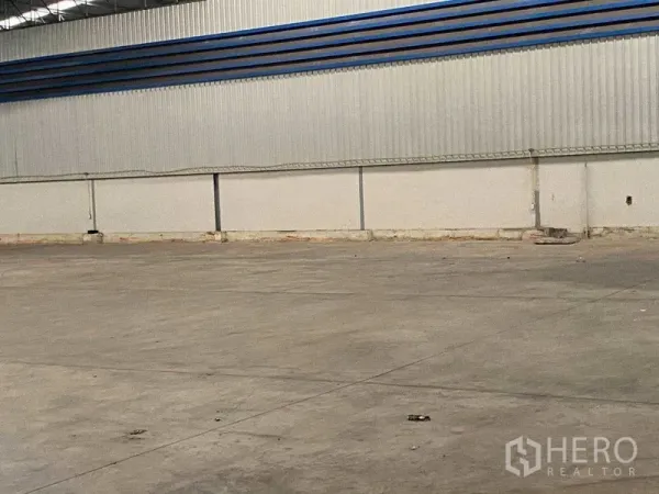 Warehouse for rent in Lat Krabang, Bangkok - Open warehouse space showing corrugated metal wall and expansive polished concrete flooring.