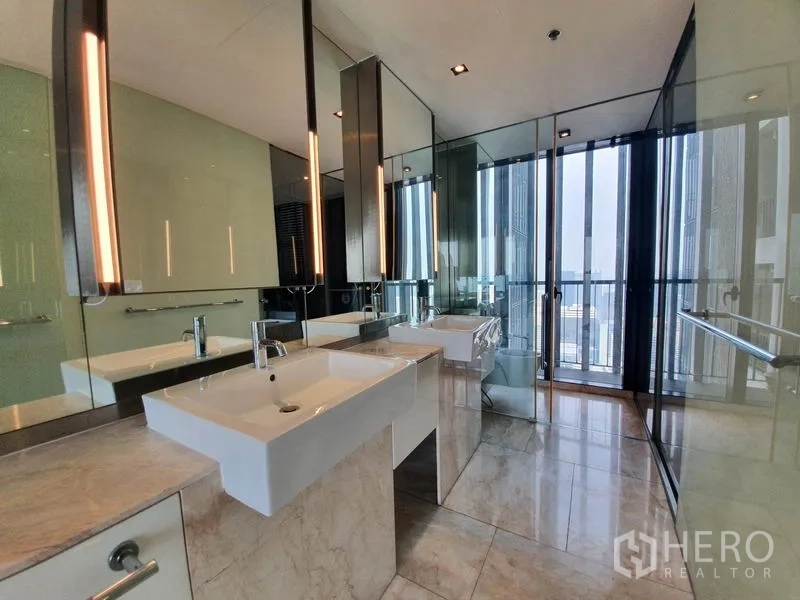 公寓 出租在Sathon, Bangkok - 豪华卫浴带双台盆、大镜面与玻璃隔断，临近阳台。