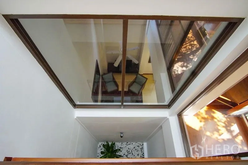 Townhouse for rent in Watthana, Bangkok - Atrium void with glass viewing panel overlooking the living area and planter.
