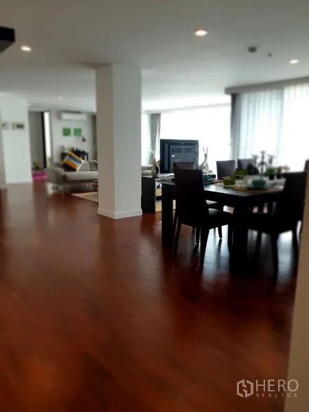 Condominium for rent in Bang Rak, Bangkok - Dining and living zones connected by wide hallway with natural light and polished wood floors.