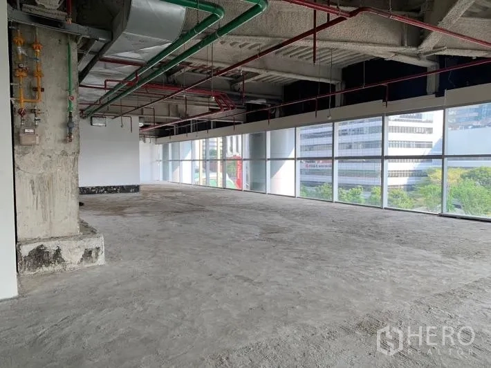 พื้นที่ขายปลีก ให้เช่า - ยูนิตเปิดโล่ง มองเห็นวิวเมืองและต้นไม้ผ่านกระจกเต็มบาน พร้อมงานระบบที่เตรียมไว้