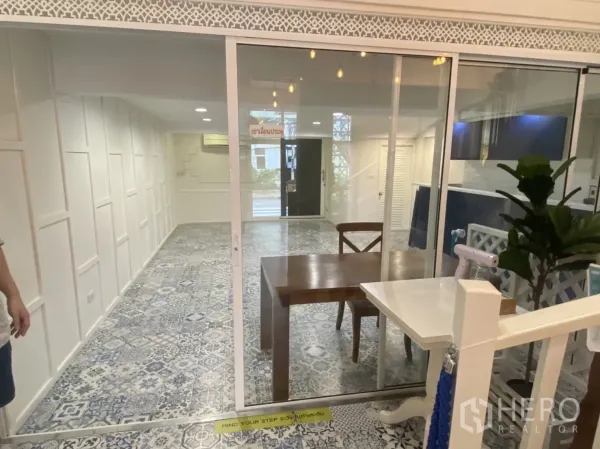 零售空间 出租在Bang Rak, Bangkok - 玻璃推拉门分隔，外侧为开敞店铺区域与花纹地砖。