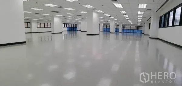 办公空间 出租在Phaya Thai, Bangkok - 全景视角的空置办公空间，多扇窗户与反光地面。