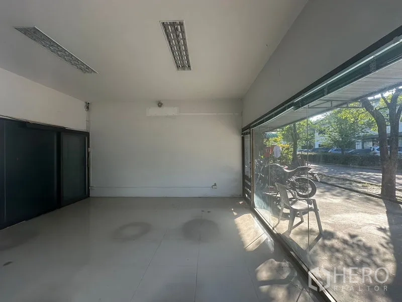 Warehouse for rent in Saphan Sung, Bangkok - Front office interior with floor-to-ceiling glass overlooking a shaded parking area.