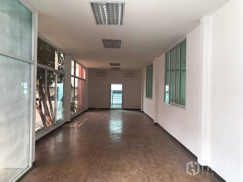 工厂 出租在Samut Prakan - 采光充足的办公室走廊，两侧落地窗。