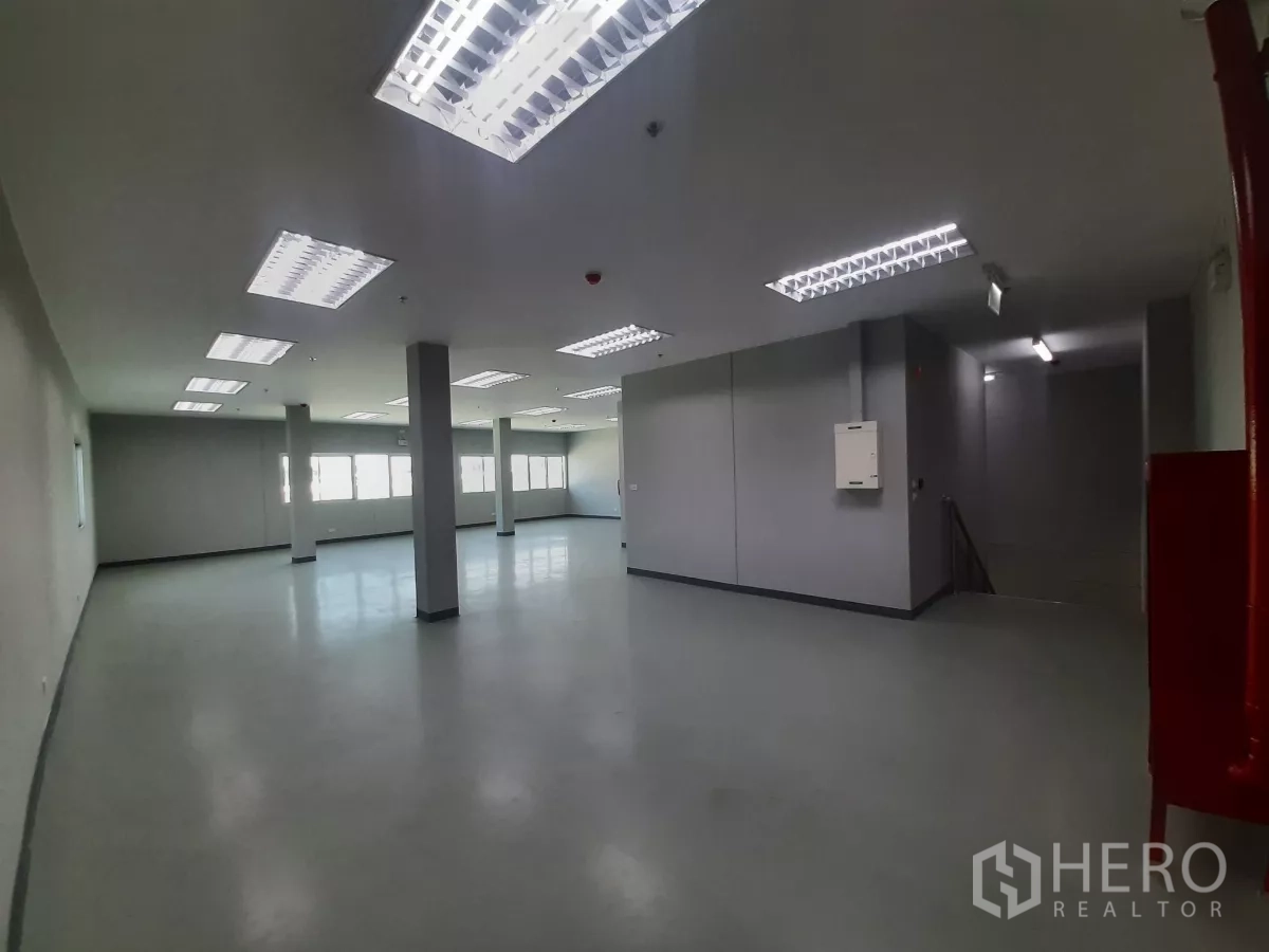 Factory for rent in Bang Lamung, Chon Buri - Open office area near stairwell with emergency exit signage.