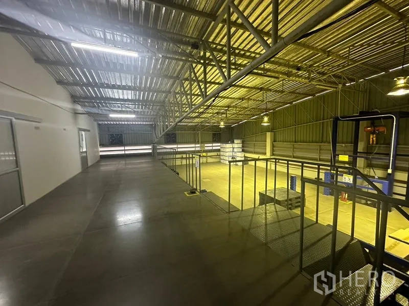 คลังสินค้า ให้เช่าหรือขายในLam Luk Ka, Pathum Thani - ชั้นลอยมองลงสู่โกดังหลังคาสูง โครงเหล็กและไฟส่องสว่าง