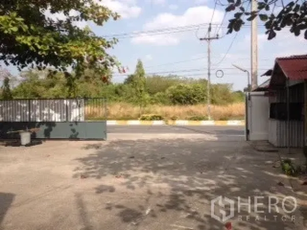 คลังสินค้า ให้เช่าในBan Chang, Rayong - ทางเข้าออกมีกำแพงและประตูรั้ว ลานคอนกรีตกว้างติดถนนด้านหน้าและมีต้นไม้รายรอบ
