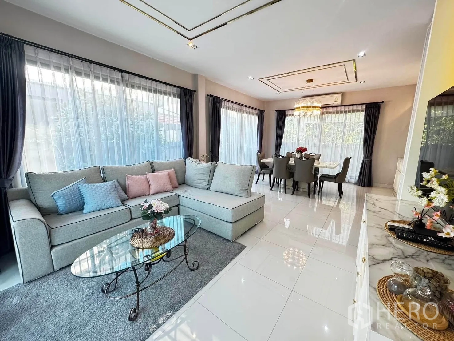 独栋房屋 for rent in Saphan Sung, Bangkok - 开放式客厅配L型沙发、玻璃茶几与大窗户。