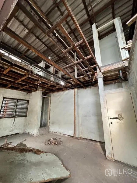 Shophouse for rent or sale in Bang Khen, Bangkok - Upper-floor area with exposed roof beams, partition walls and a small window.