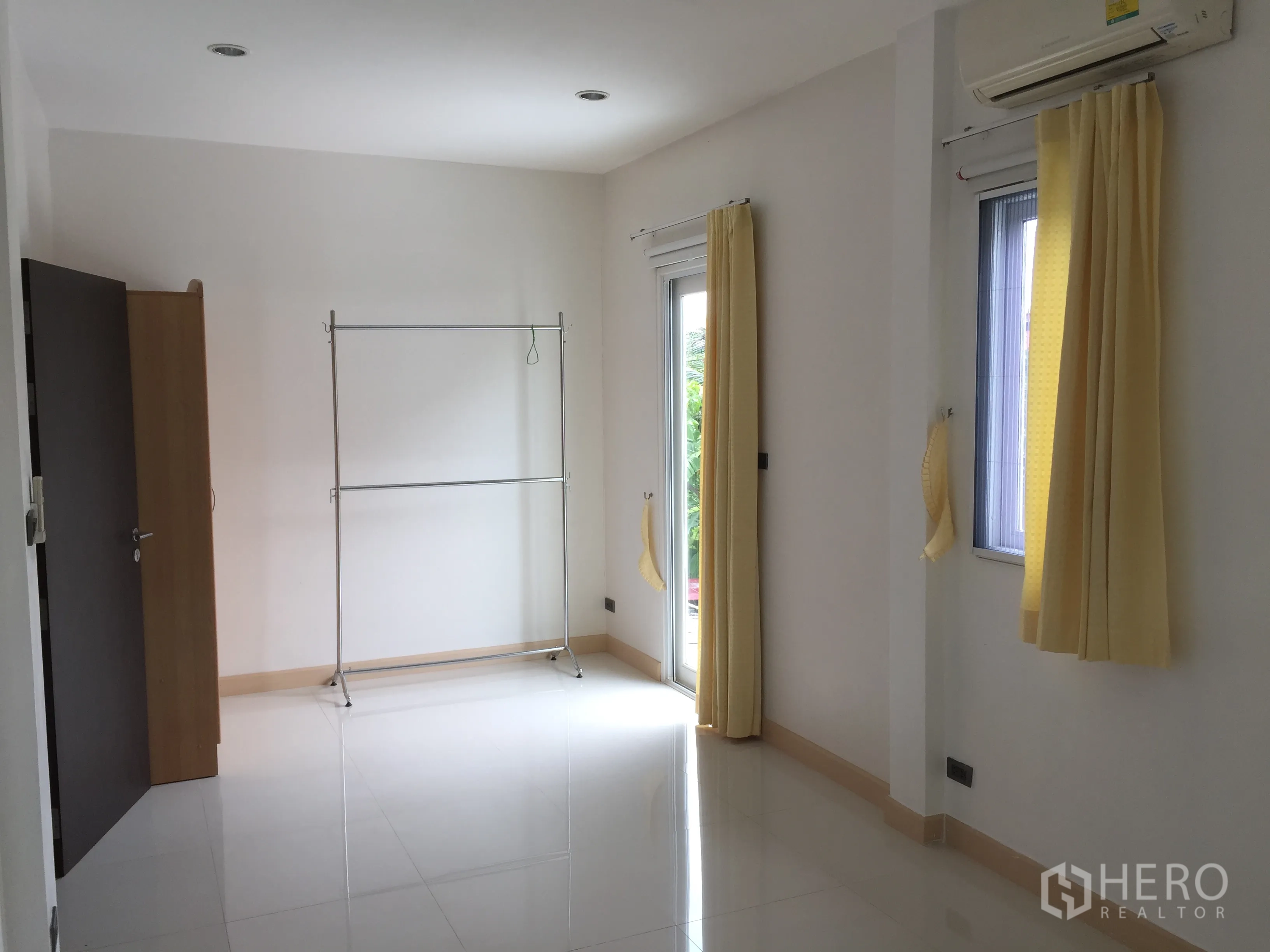 ทาวน์เฮาส์ ให้เช่าในDin Daeng, Bangkok - ห้องโทนขาวกว้างขวาง มีผ้าม่านสีเหลือง เครื่องปรับอากาศ และประตูออกระเบียง