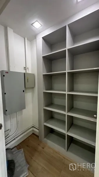 零售空间 出租 - 带内置层架与配电箱的小型储物间。