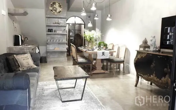 联排别墅 出租在Watthana, Bangkok - 开放式客餐厅，抛光水泥质感与吊灯相得益彰。