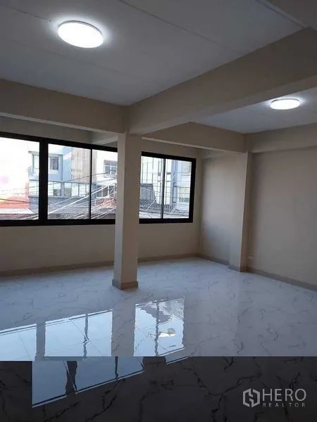 Shophouse for rent in Bang Kapi, Bangkok - Sunlit upper level with wide windows and polished flooring.