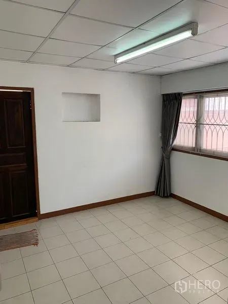 办公空间 出租在Chatuchak, Bangkok - 明亮房间，白色地砖，带防盗窗与窗帘的窗户。