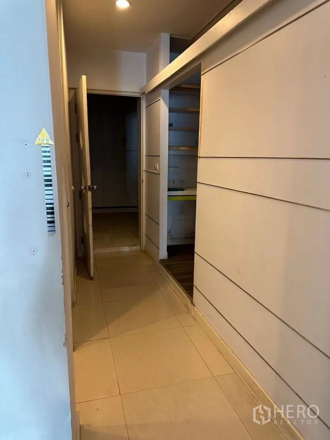 อาคารพาณิชย์ ขายในWatthana, Bangkok - ทางเดินแคบมีชั้นเก็บของและประตูเชื่อมไปยังห้องด้านหลัง.