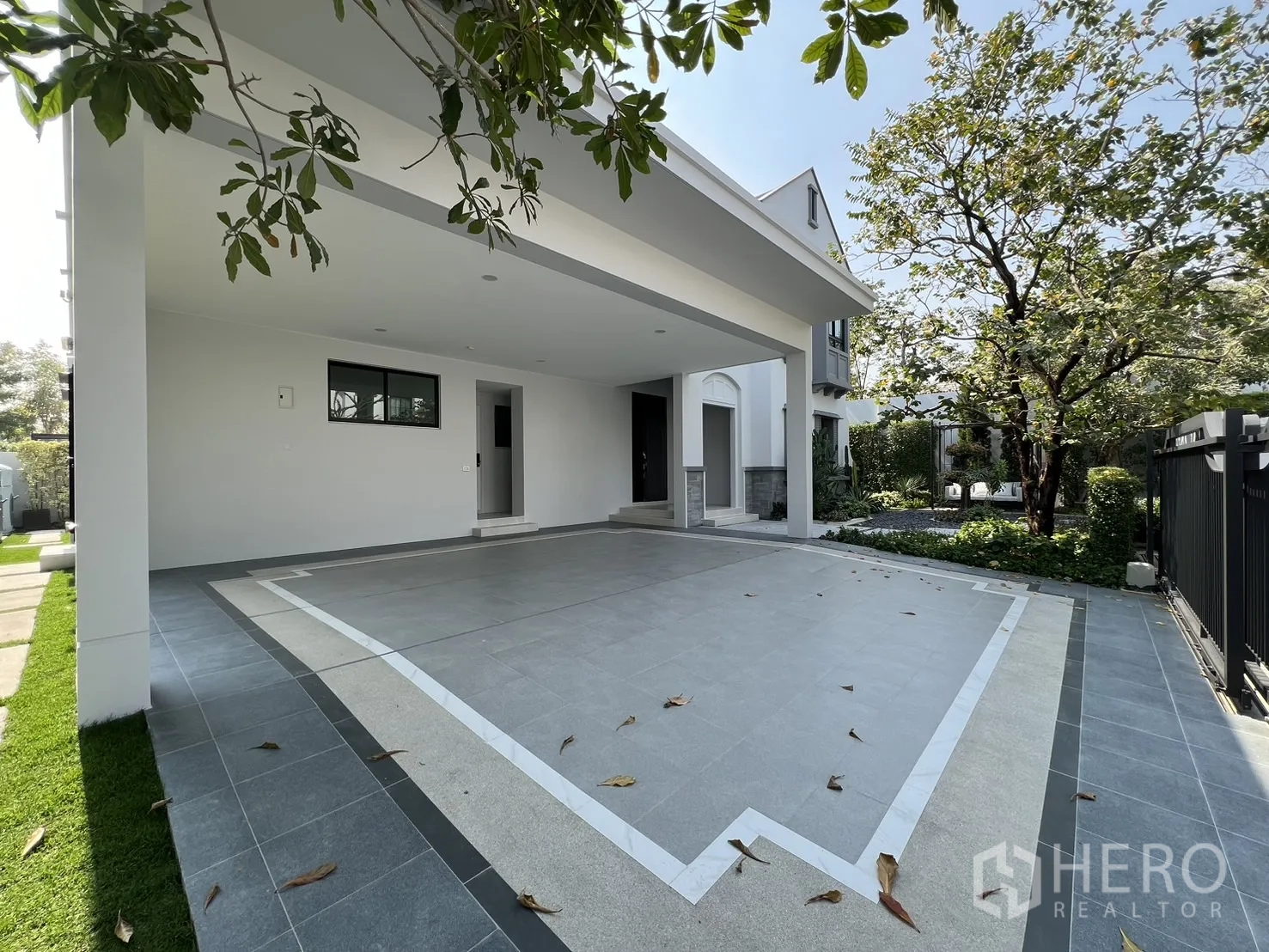 Detached House for rent in Saphan Sung, Bangkok - Covered four-car carport with tiled floor beside landscaped garden.