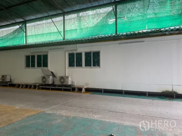 คลังสินค้า ให้เช่าในLam Luk Ka, Pathum Thani - ด้านข้างอาคารมีช่องหน้าต่าง คอมเพรสเซอร์แอร์ และสแลนกันแดดเหนือทางโหลด