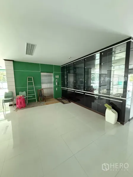 货栈 出租在Mueang Samut Prakan, Samut Prakan - 一层大堂，设货运电梯与黑色玻璃展示柜。