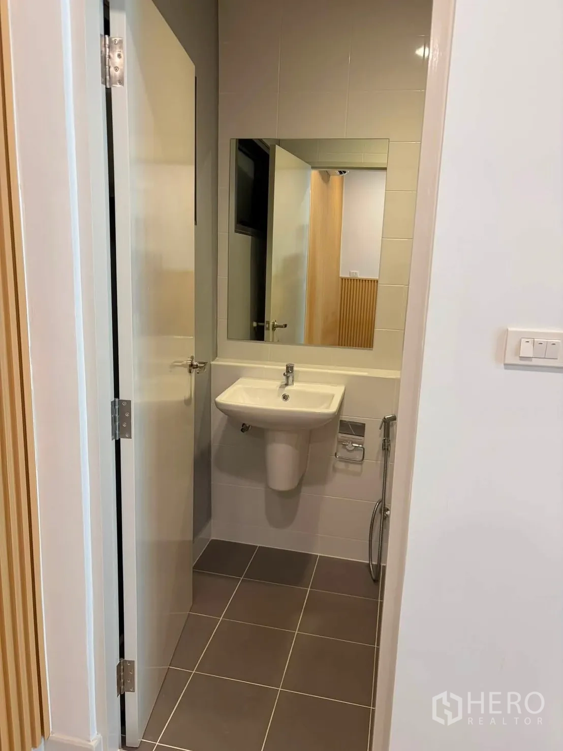Townhouse for rent in Bang Phli, Samut Prakan - Compact bathroom with pedestal sink, mirror and handheld bidet spray.