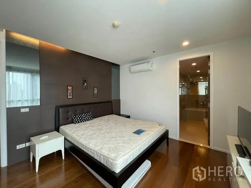 คอนโด ให้เช่าหรือขายในWatthana, Bangkok - ห้องนอนหลักพร้อมเตียงบุผ้า ผนังตกแต่ง เครื่องปรับอากาศ และทางเชื่อมเข้าห้องน้ำในตัว