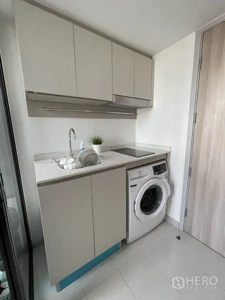 公寓 出租在Sathon, Bangkok - 明亮小厨房，水槽、电磁炉、顶柜与前置式洗衣机。