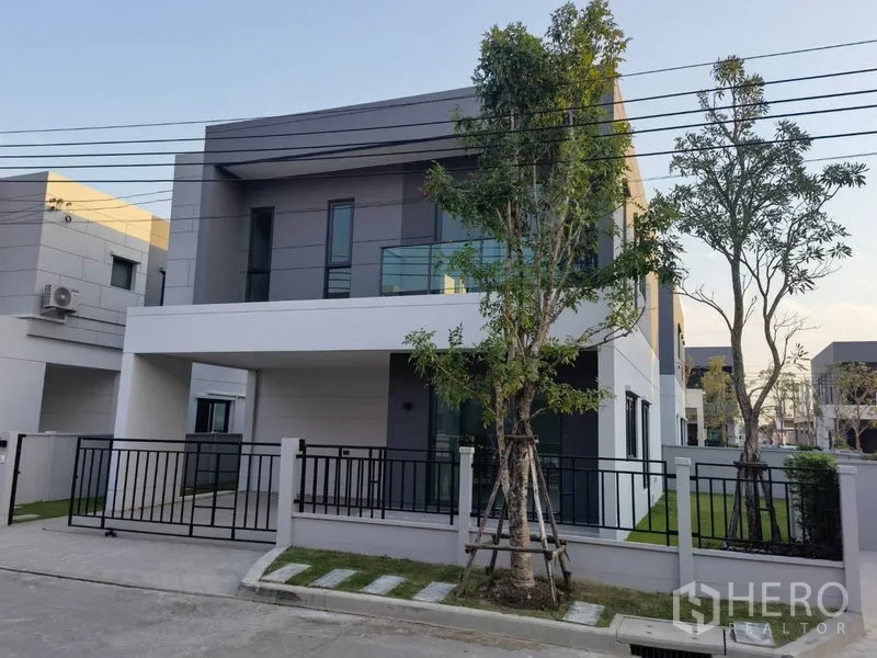 Detached House for rent in Bang Phli, Samut Prakan - Modern two-storey detached house with gated driveway and trees.