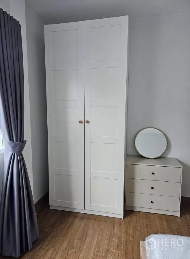 Detached House for rent in Bang Phli, Samut Prakan - White wardrobe with three-drawer dresser and round mirror in the bedroom.