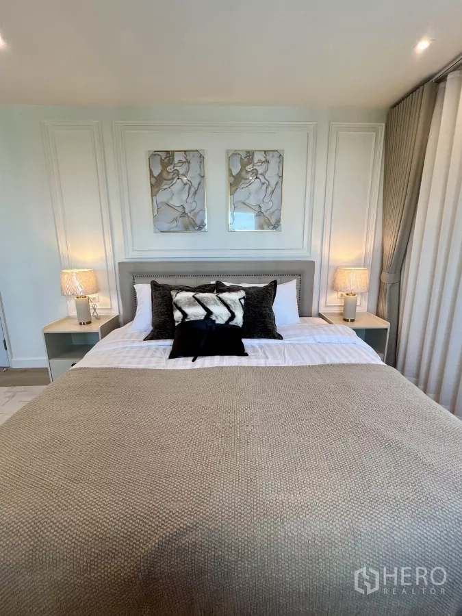 公寓 出售在Yan Nawa, Bangkok - 温馨卧室，软包床头、墙面装饰画与柔和灯光。