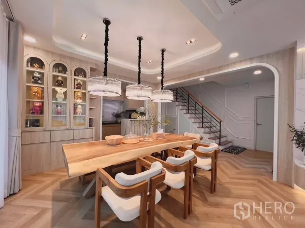 Detached House for rent in Bang Phli, Samut Prakan - Dining area with glass display cabinet, crystal pendants and staircase to the upper floor.