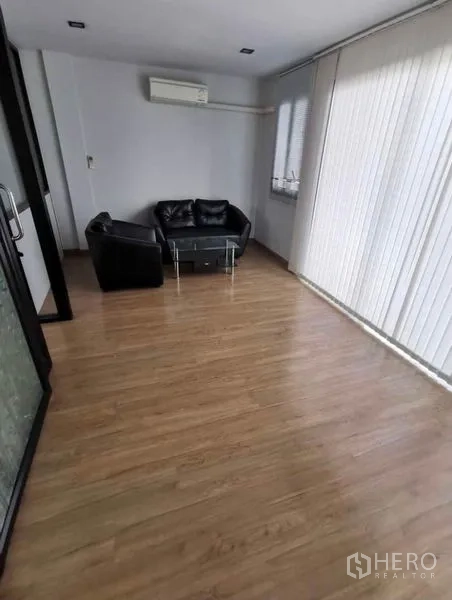 Home Office for rent in Prawet, Bangkok - Small lounge area with black sofa set beside floor-to-ceiling vertical blinds