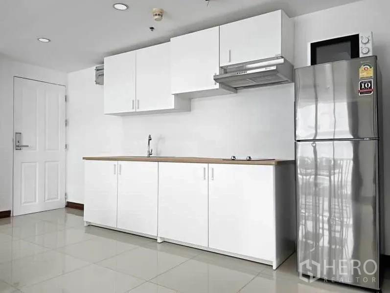 คอนโด ให้เช่าในKhlong Toei, Bangkok - ครัวบิวท์อินสไตล์มินิมอล ตู้สีขาว ท็อปไม้ เครื่องดูดควัน และตู้เย็นสแตนเลส