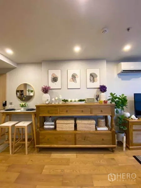 คอนโด ขายในRatchathewi, Bangkok - ผนังห้องนั่งเล่นพร้อมตู้ไม้ ภาพกรอบตกแต่ง ไฟดาวน์ไลท์ และเครื่องปรับอากาศ