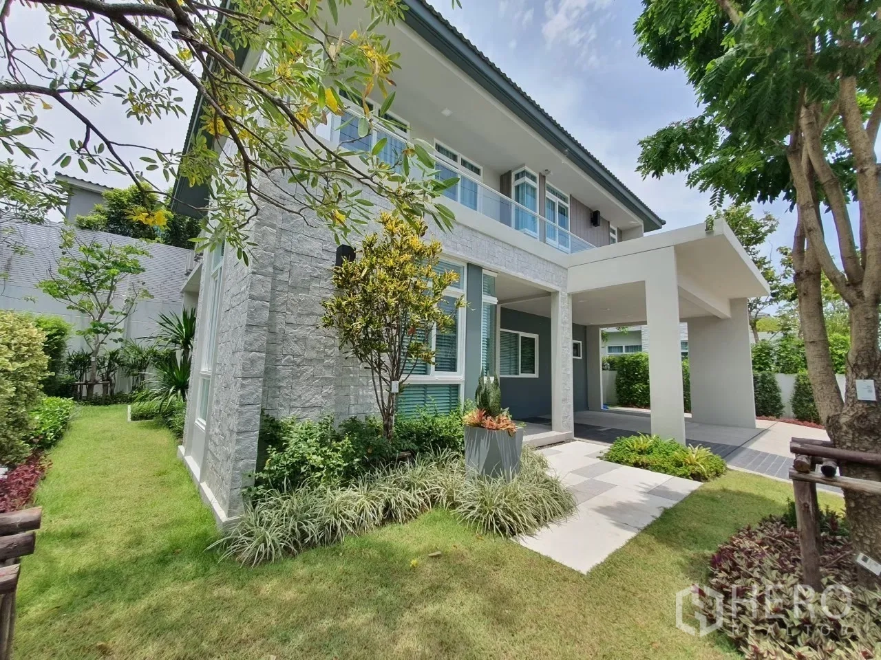 บ้าน ให้เช่าในPrawet, Bangkok - มุมมองด้านข้างมีสวนตกแต่ง ผนังหิน และเฉลียงหน้าบ้าน.