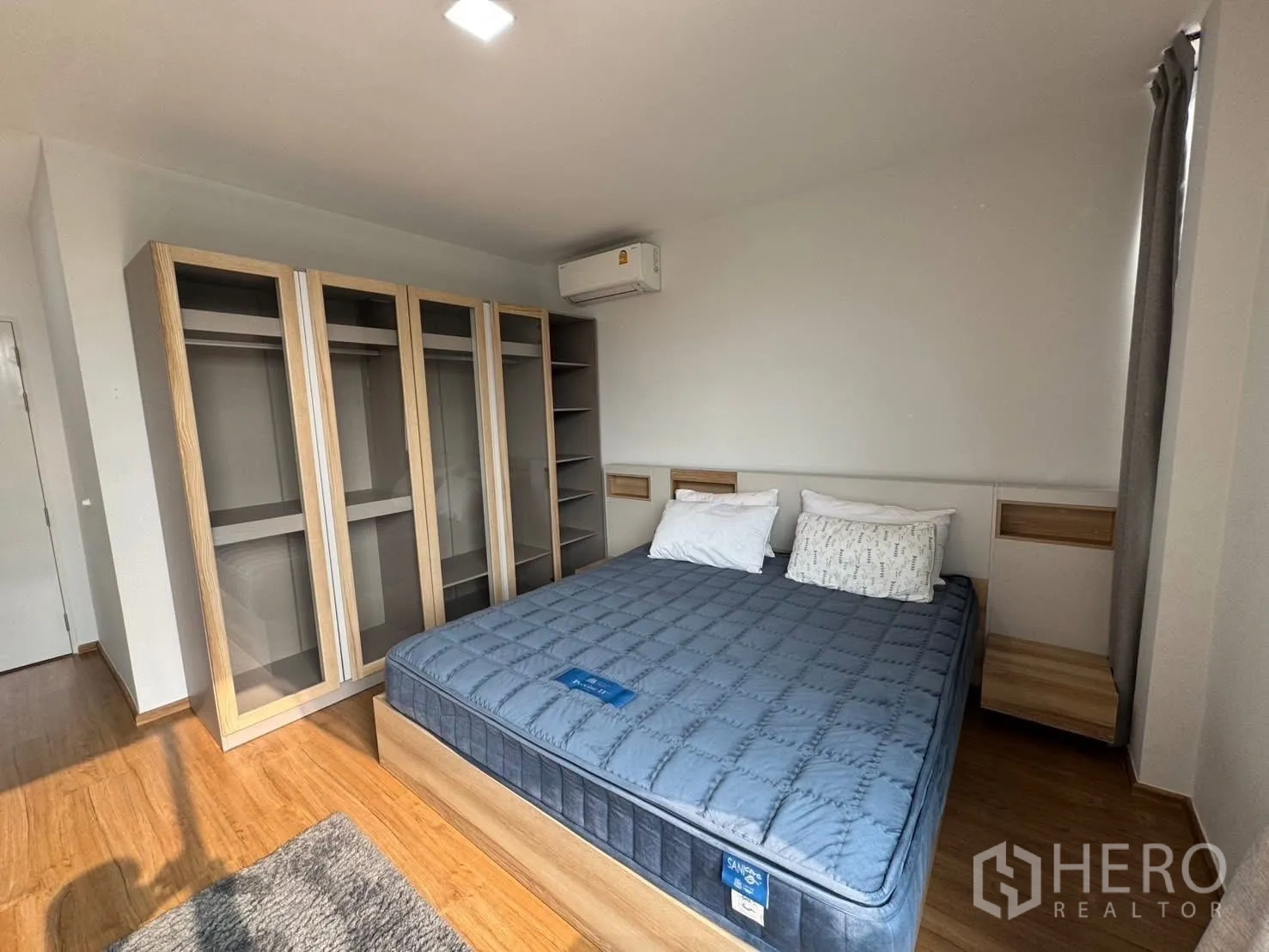 Townhouse for rent in Bang Phli, Samut Prakan - Bedroom showcasing wall-length glass-door wardrobes and a queen bed.