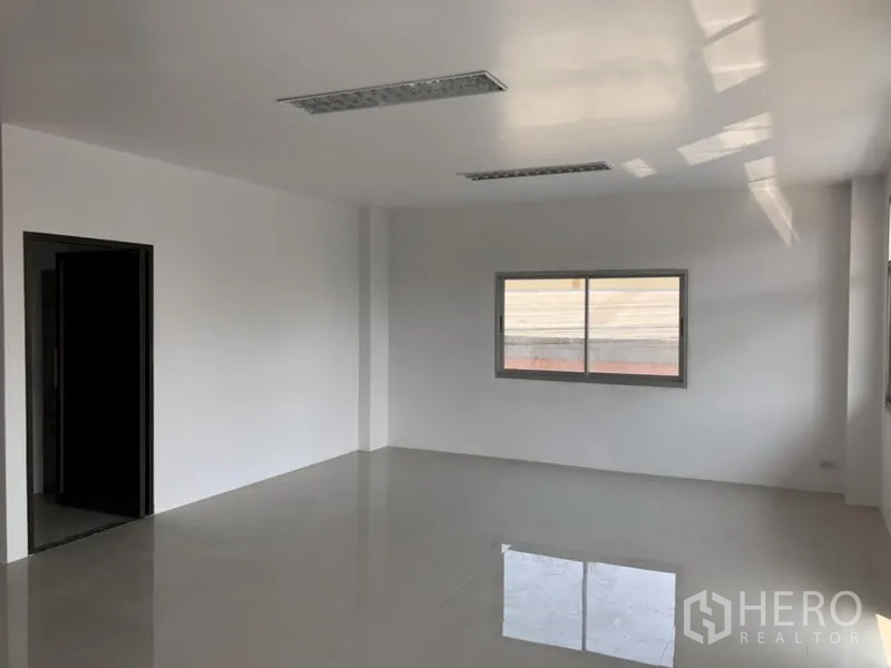Factory for rent in Pathum Thani - Bright second-floor office room with window and polished tile flooring.