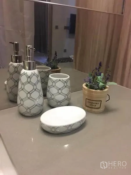 公寓 出租在Watthana, Bangkok - 现代浴室台面，带皂液器、皂盘与镜面。