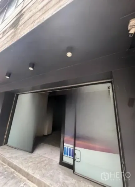 อาคารพาณิชย์ ให้เช่าในBang Rak, Bangkok - ทางเข้าชั้นล่างประตูกระจกบานเลื่อนพร้อมกันสาดสีดำและไฟสปอตไลต์