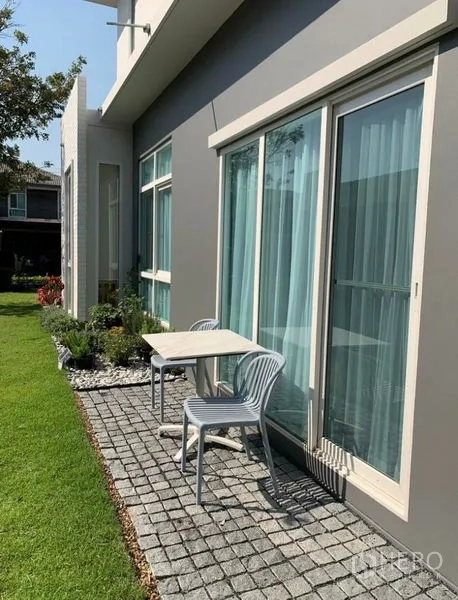 Detached House for rent in Bang Phli, Samut Prakan - Garden patio with sliding glass doors and a small table with two chairs.